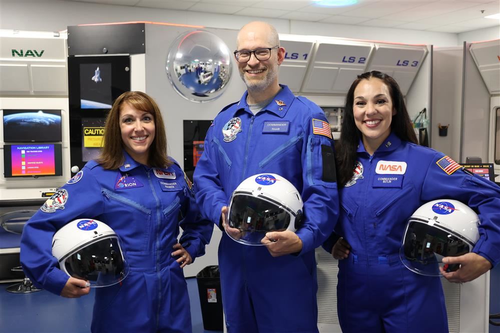 Three Mission Commanders standing in a spacecraft