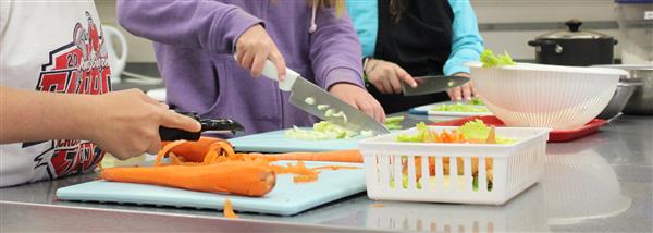 Students peeling and chopping vegetables Students peeling and chopping vegetables
