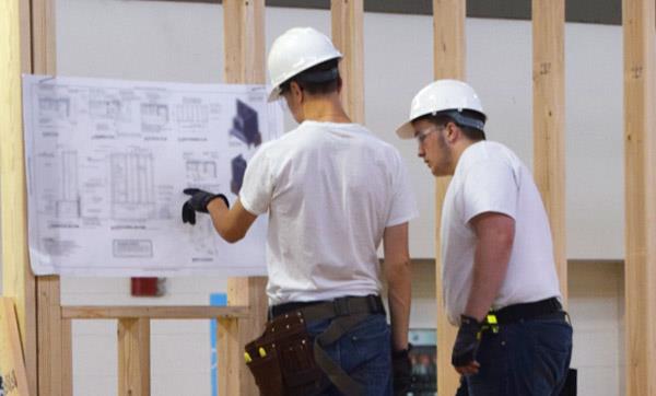 Students examine blueprints for a construction project Students examine blueprints for a construction project