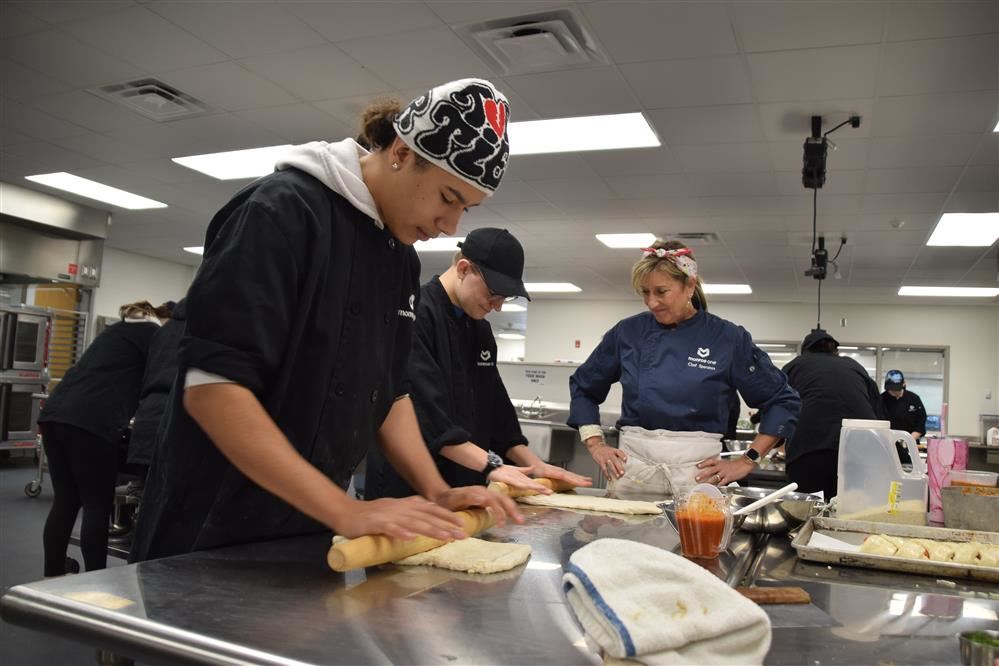 EMCC Culinary Arts students roll dough for pizza bread. EMCC Culinary Arts students roll dough for pizza bread.