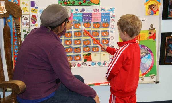EMCC student and Teens-N-Tots Preschooler point to a date on the class calendar EMCC student and Teens-N-Tots Preschooler point to a date on the class calendar