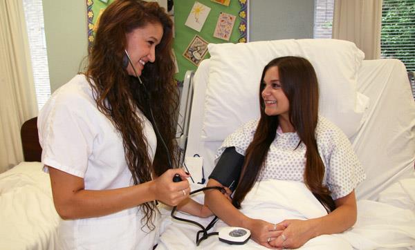 Student takes volunteer "patient's" blood pressure Student takes volunteer "patient's" blood pressure