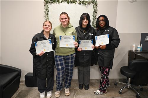 Four Cosmetology students smile with their Volunteer Appreciation Certificates.