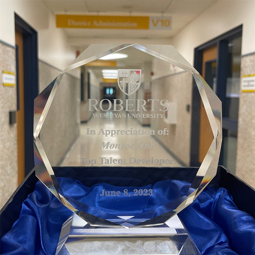   close up of glass award naming Monroe One as Top Talent Developer