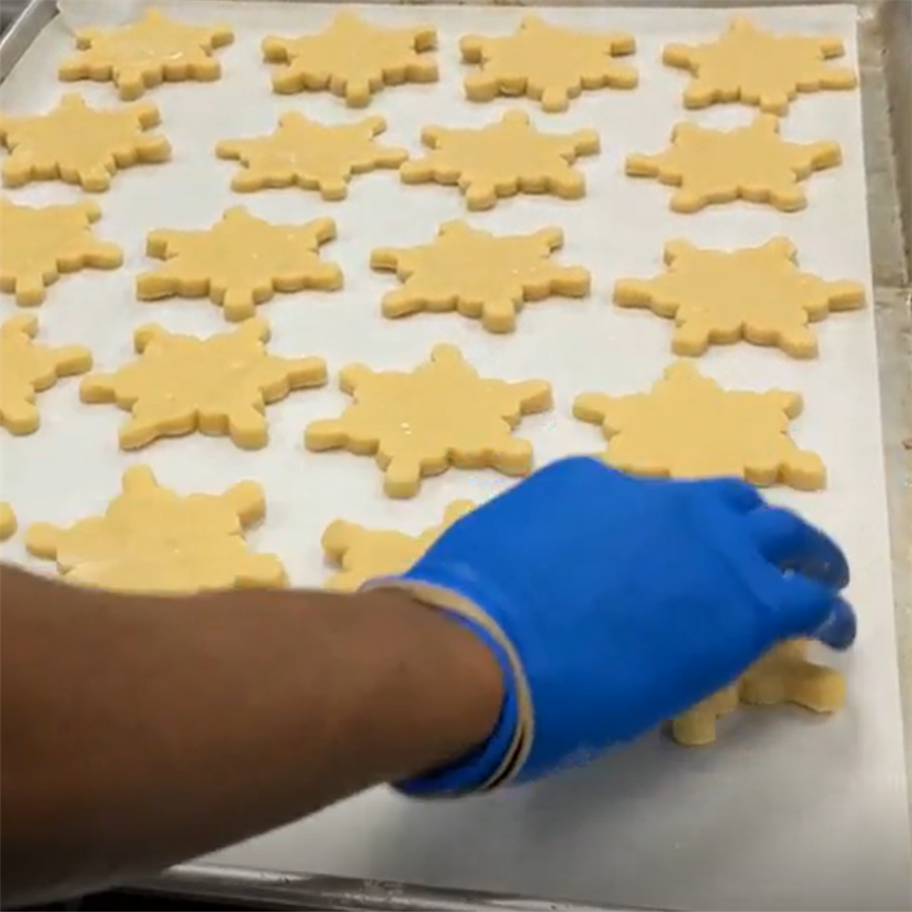 baking sheet lined with snowflake shaped cookie dough